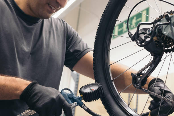 istock anonymous bicycle mechanic inflating the wheel in workshop 1976058428