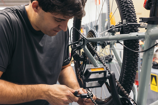 caucasian mechanic in garage changing bike transmission