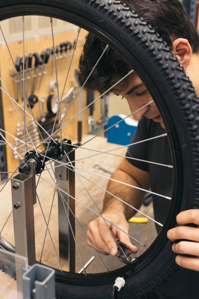 istock vertical closeup mechanic with tool to adjust bicycle spokes 1976058454