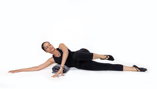 front kick pose, in the studio isolated on white. Specialized trauma releasing exercises for elderly people, 55 years old woman trainer posing for exercises.