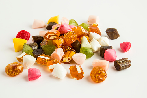 High angle view close-up of an assortment of colorful jellybeans, lollipops, candies and marshmallows.