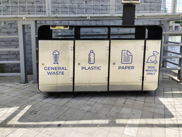 istock Steel containers for separate garbage collection with appropriate inscriptions are located on the tiled sidewalk 1976087847