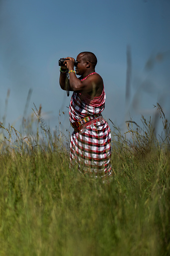 A safari ranger using binoculars to survey the area