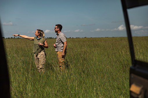 Young people taking in the views of the African Savannah from outside the SUV