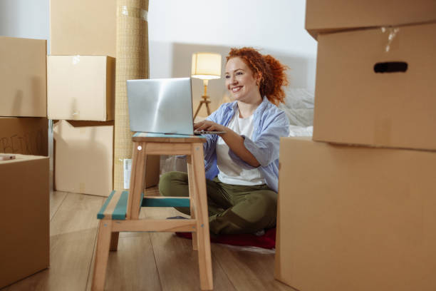 istock Young woman using laptop in new apartment 1976143105