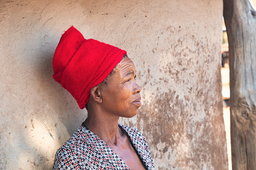 portrait of an village African woman in front of the hut at sunset, village in Botswana