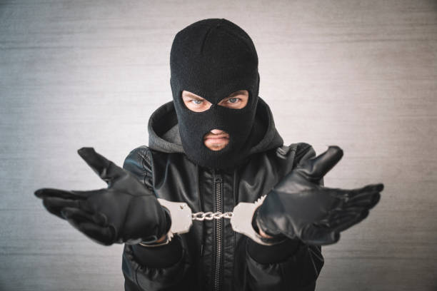 istock dangerous criminal is handcuffed in prison for interrogation. A repentant sad man with his head on the table. Arrest of a bandit. 1976187797