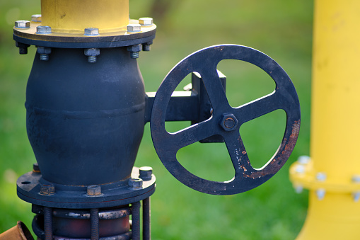 Fire extinguishing module with heat flow on gas pipes. Close up of oil and gas pipelines and valves on green grass background