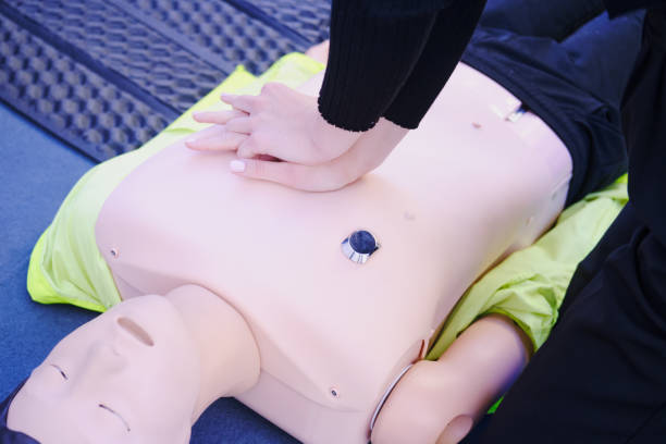 istock First aid training - CPR on a mannequin. Woman doing resuscitation to a training dummy in the emergency room 1976193563