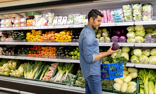 Healthy eating man grocery shopping at the supermarket - lifestyle concepts