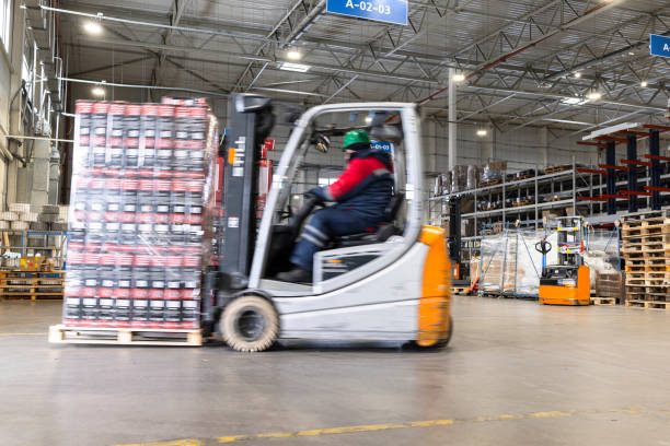 Using a forklift, a warehouse worker transporting goods.
