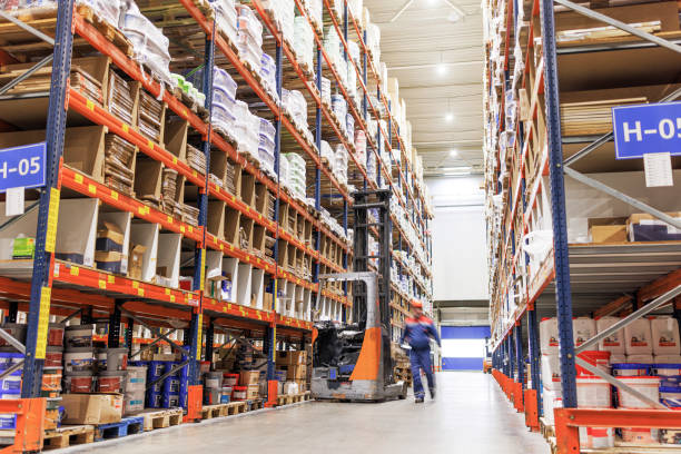 istock A worker preparing to carry goods with a forklift in a warehouse. Blurred motion effect. 1976227822