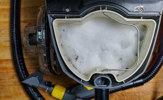 Soapy water in professional vacuum-cleaner, dirty after washing the sofa.