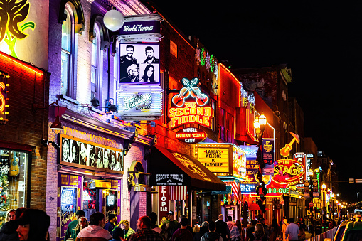 Nashville, TN, USA - 12-24-2023: Famous Neon signs of blues clubs on Beale street illuminated at night in downtown Nashville city attraction