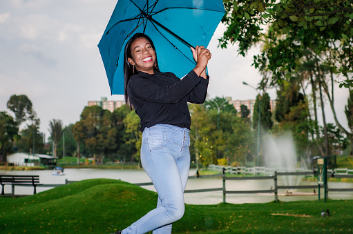 portrait of confident black woman dressing casual clothes on a rainy day in public park