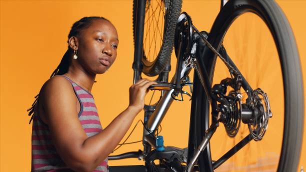 istock Engineer checking bicycle performance by spinning bike wheel during maintenance 1976324762