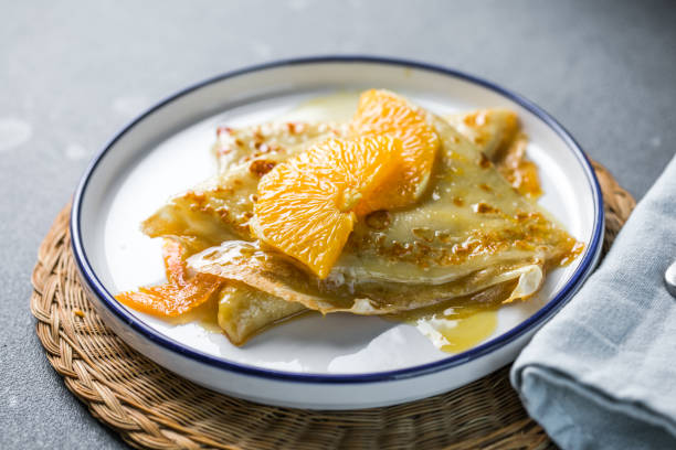 Delicious crepes suzette with orange syrup on plate