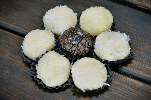 Delicious brigadeiro sweets and flower-shaped coconut sweets under the table for birthday party