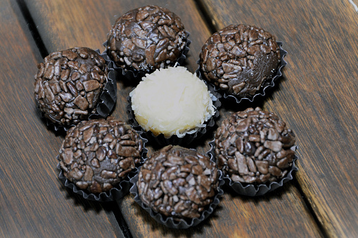 Delicious brigadeiro sweets and flower-shaped coconut sweets under the table for birthday party