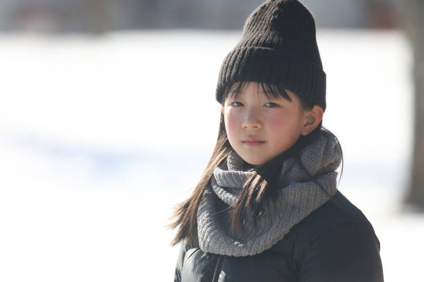 istock girl standing on a snowy field 1976439914