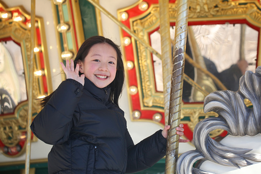 Happy girl is smiling on Ferris wheel in an amusement park