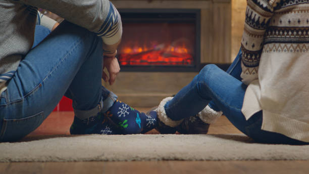 istock Young couple with warm socks in front of fireplace 1976490047