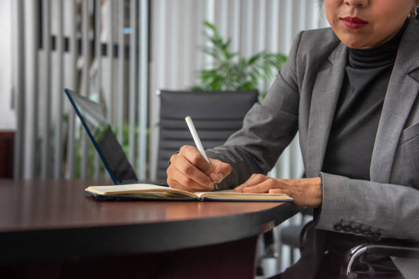 istock Mexican entrepreneur smiling and writing important topics in a notebook, handwriting 1976499408