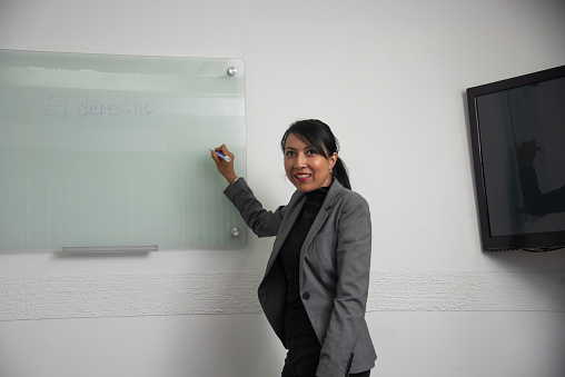 Mexican entrepreneur writing on a boardroom whiteboard before starting a presentation