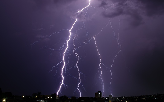 a beautiful purple lightning falling on a stormy night