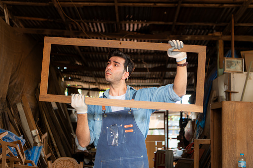 Carpenter working at his carpentry shop. Eyesight is utilized to ensure accuracy.