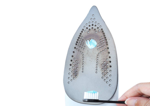 Burnt dirty electric flat iron. Clean an base surface with Toothpaste. burnt iron for ironing. Cleaning the iron from carbon deposits