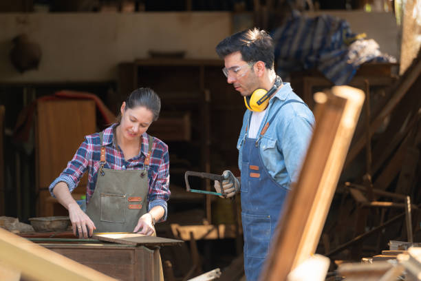 istock Carpenter and his assistant working together in a carpentry workshop 1976613255