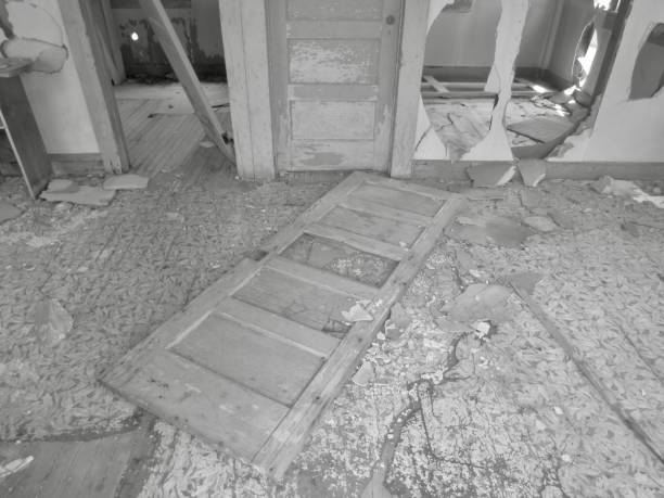 Architectural detail from an old abandoned and partly ruined house in Greece. The image was captured on black and white grainy ISO 400 film by an analogue film camera and a short telephoto prime lens. The granularity is real film grain (due to the presence of small particles of a metallic silver on the negative). The negative was captured by a a digitizer kit connected to a 60mm f/2.8 macro lens and a full-frame DSLR camera, and converted to a positive by software. Minimal post processing has been done (only adjustment of histogram). The image is part of a series of abandoned and partly ruined houses.