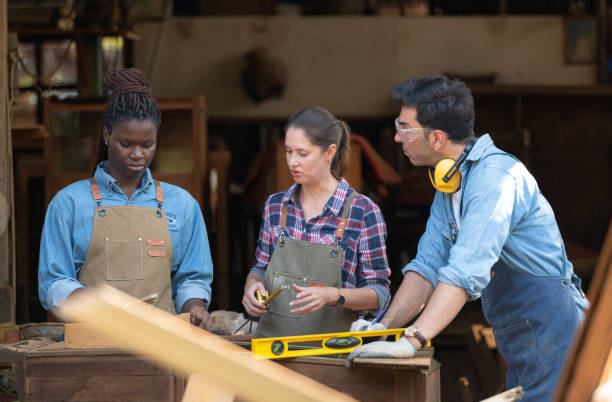 istock Carpenter and his assistant working together in a carpentry workshop 1976615290