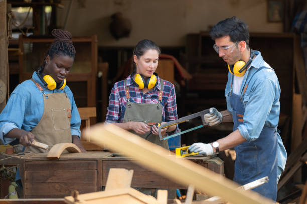 istock Carpenter and his assistant working together in a carpentry workshop 1976615807