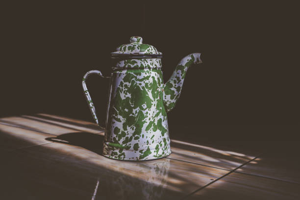istock an old enamel teapot on the floor and exposed to the light 1976618367