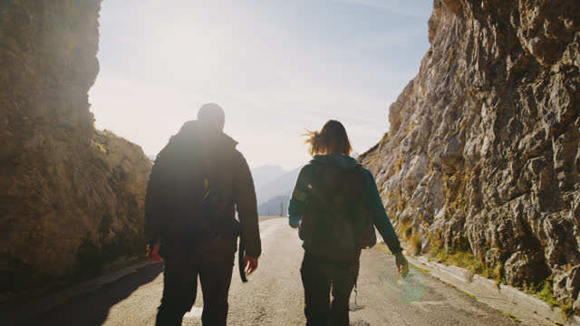 SLO MO Emerging into Light: Adventurous Couple Exiting Mountain Tunnel