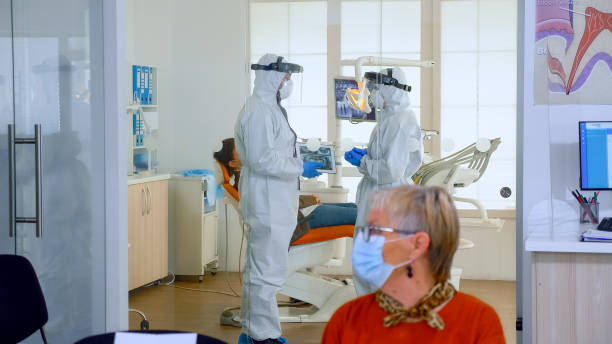 istock Doctors in full virus protection uniform talking in surgery room 1976660182