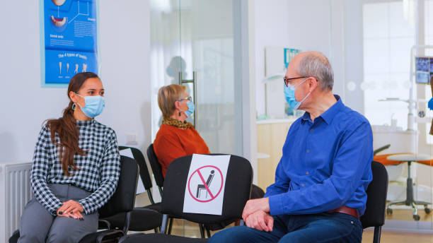 istock Patients with masks talking sitting on chairs keeping social distance 1976676751