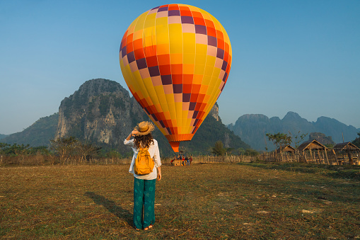 Elegant woman standing on the background of hot air balloon