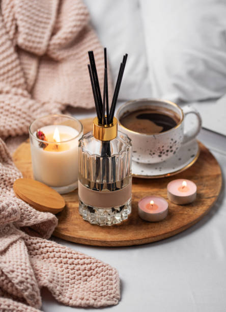 istock Bamboo sticks in bottle with scented candles and cup of coffee 1976720482