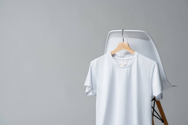 istock White blank t-shirt hanging on chair in empty room 1976726764