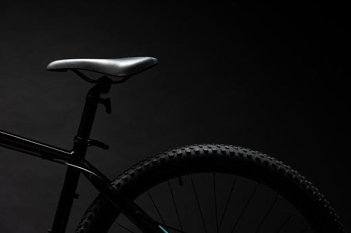 Black mountain bicycle on black background close up photo