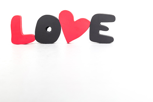 Word LOVE made of red and black volumetric letters and heart on white background. Valentine's day, love day and wedding concept. High quality photo
