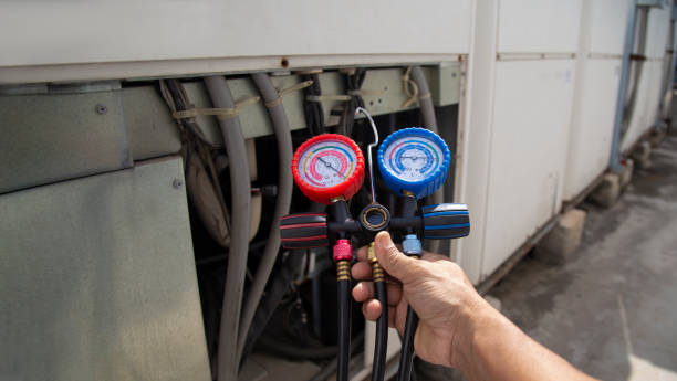 istock Air conditioning, HVAC service technician using gauges to check refrigerant and add refrigerant. 1976742324