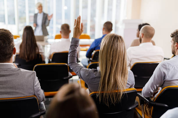 istock Back view of a female entrepreneur asking a question on a seminar. 1976758733