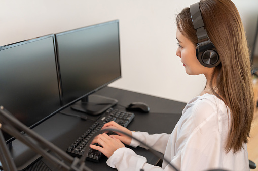 Mid adult woman working using a laptop on the call center at office