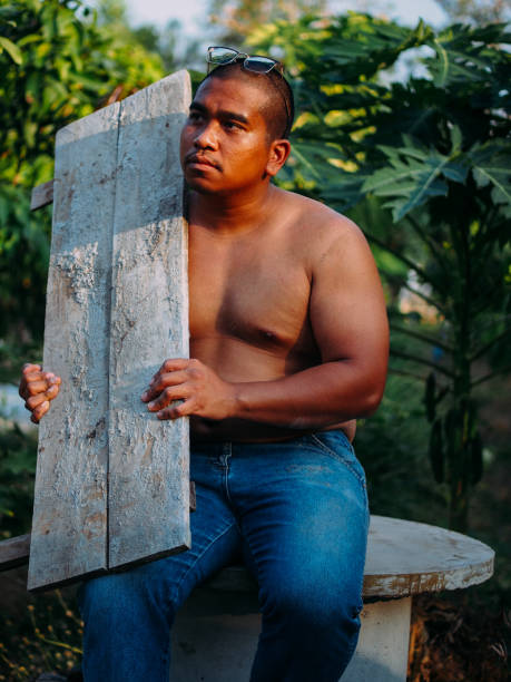 brown man carry wooden board