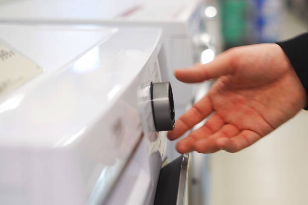 istock A white man's hand adjusts the knob on a washing machine 1976809861