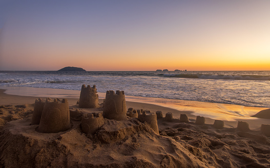 A Sand castle on the beach during sunset with space for text